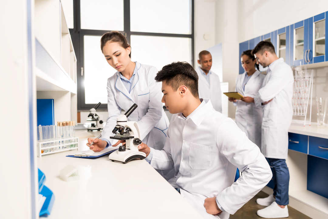 young-lab-technicians-working-with-microscope